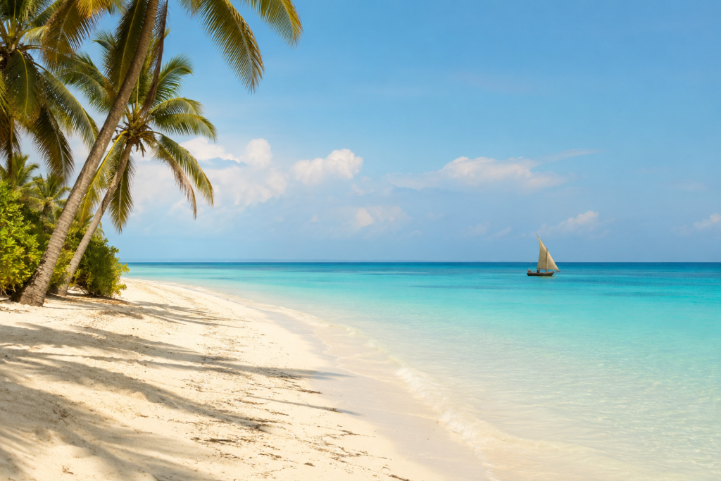 Zanzibar budget travel guide feature image — pristine white sand beach with crystal clear turquoise water and a traditional dhow sailing boat on the horizon representing the Zanzibar travel experience