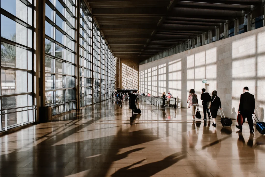 Travellers walking through an airport terminal with luggage